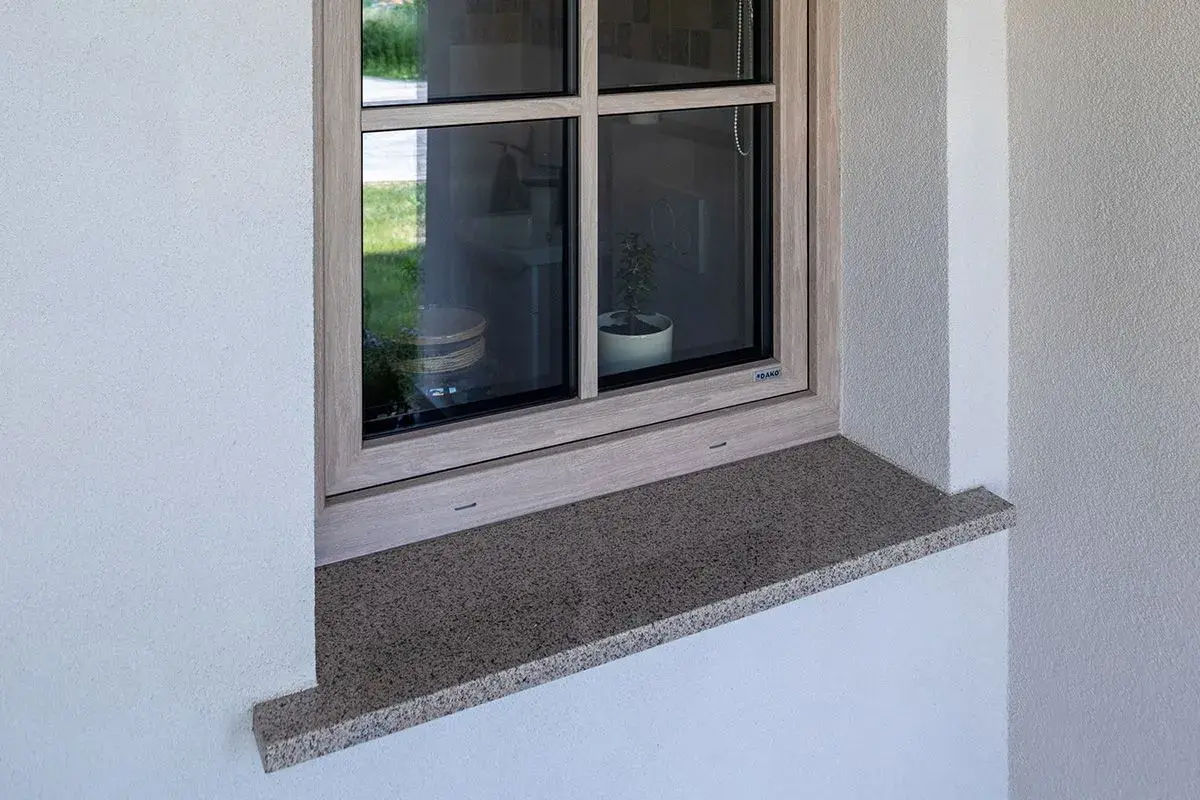 Kamienny parapet zewnętrzny wystaje ok. 5 cm, chroniąc elewację. Idealna proporcja, by wiedzieć, ile powinien wystawać parapet zewnętrzny.